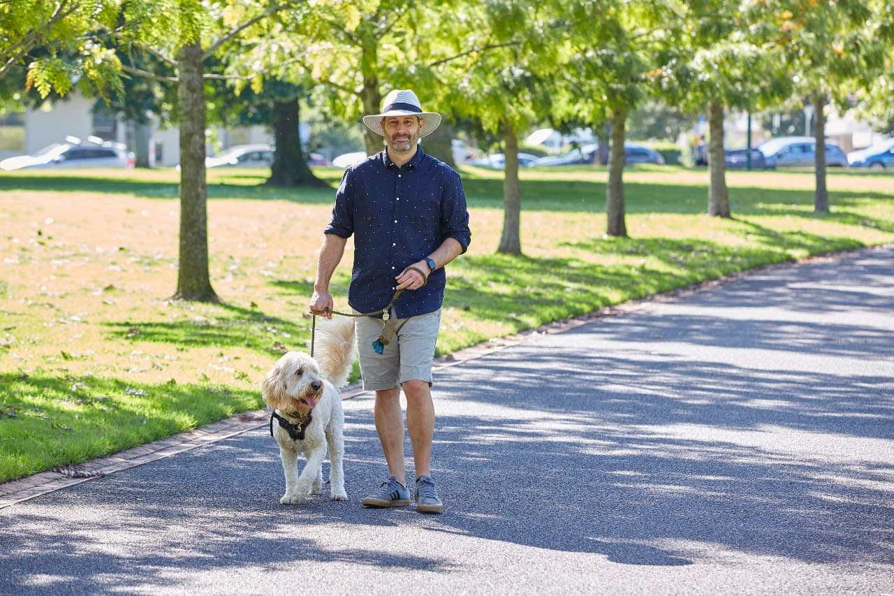 A man walks a dog in the park
