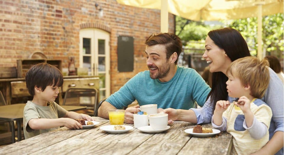 Parents with two toddlers sitting at a table