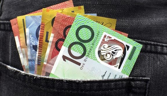A row of Australian dollar bills stick out of a back pocket