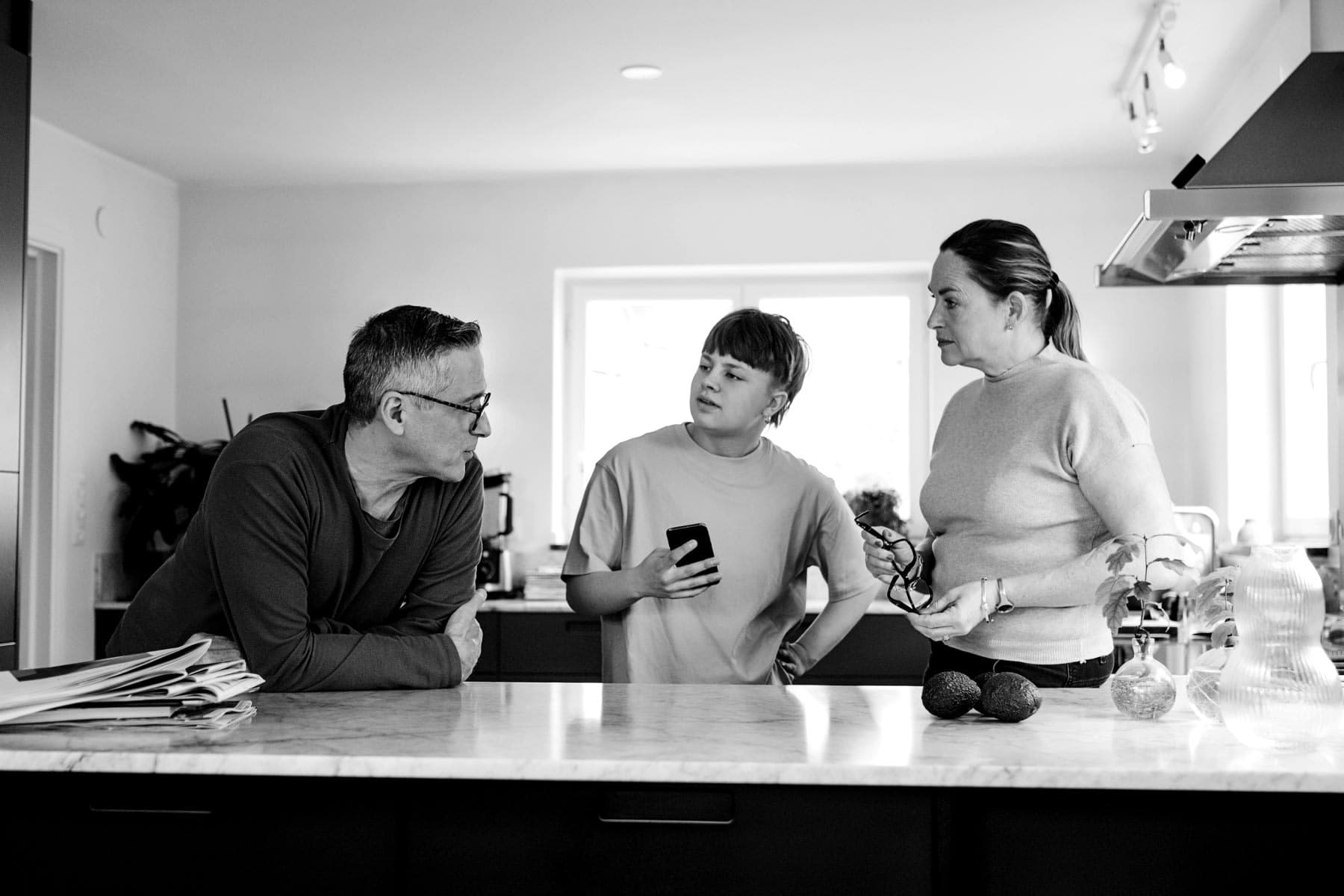 Parents speaking with their son in the kitchen