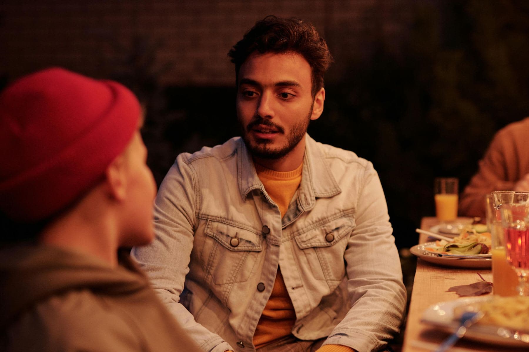 Two young men in conversation at a dinner party.