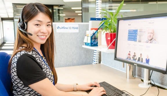 Woman smiles at camera while at desk